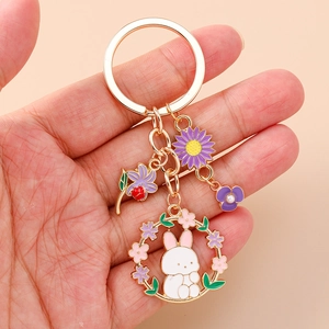 Detailed close-up of a golden flower rabbit keychain with enamel charms and pearls