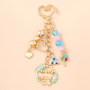 Detail of floral beaded keychain with hollow heart pendant and Happy Holidays text