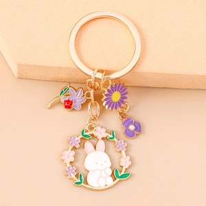 Detail of a floral rabbit keychain with enamel charms and purple sunflower pendant