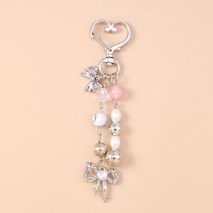 Detailed view of beaded keychain featuring pink pearls, heart lock and silver bow charms