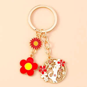 Detailed view of alloy keychain featuring enamel sunflower and white cat charms