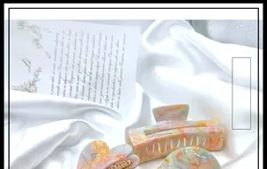 Detail of colorful marble acetate hair clips in heart and rectangular shapes on silk fabric
