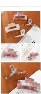 Detail view of marble acetate hair claw clips in floral pink and cream white colors
