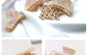 Detailed macro view of marble textured hair claw clips with elegant golden metal teeth