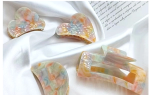 Close-up of four-piece acetate hair claw clips set in pastel macaron marble patterns