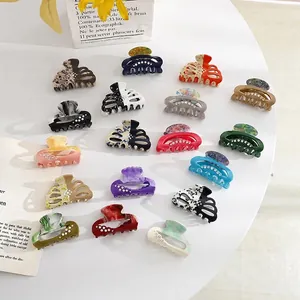 Acrylic hair claw clips with diamond accents in various colors on a white table