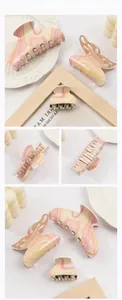 Close-up of three butterfly hair claws featuring a pink and yellow marble resin design