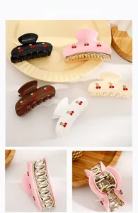 Macro detail of French cherry rhinestone hair claw clip showing durable metal spring mechanism