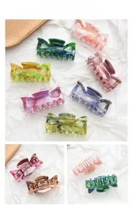 Detail showing marble textured acetate hair claws in various colors with cross-teeth design