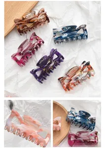 Detail showing colorful marble texture acrylic bow hair claws with metal spring mechanism