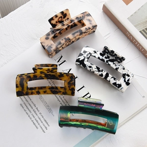 Set of four stylish rectangular hair claws in leopard, marble, and aurora gradient finishes