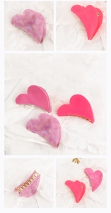Detail view of heart-shaped acetate hair clips with purple marble and pink textures