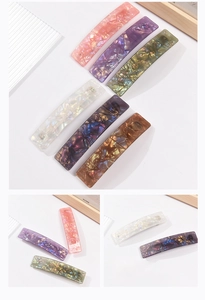 Detailed macro view of acrylic hair clips with marble texture and metal spring fasteners