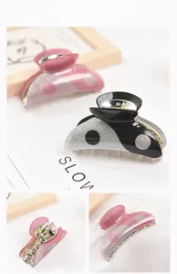 Macro detail of yin yang acrylic hair claw clips with pink and black glitter finish