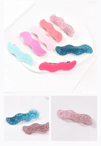 Detail showing colorful wavy acrylic hair clips with glossy and glitter finish textures
