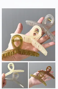 Macro detail of 13cm oversized resin hair claw clips in olive green and beige colors