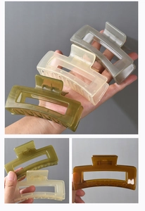 Detail showing the internal metal spring mechanism of a large matte rectangular hair claw clip