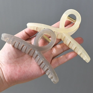Extra large 13cm matte hair claw clip in cream and grey colors held in hand
