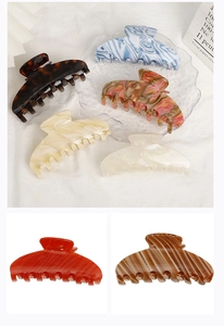 Close-up of large acetate hair claws in various colors like marble blue and tortoiseshell