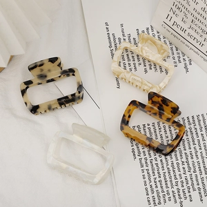 Set of four hollow rectangular acetate hair claws in tortoiseshell and marble patterns
