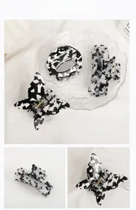 Detailed view of black and white marble pattern acetate hair claws in various shapes