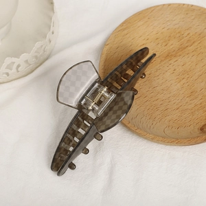 Elegant grey checkered acetate hair claw clip on a minimalist wooden tray display