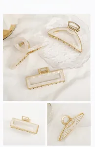 Detailed set of three acetate shark hair clips in pearl white and gold finish