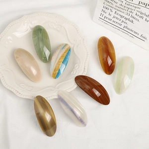 Elegant acetate oval hair clips set with marble texture on a white decorative plate