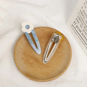 Floral acetate BB hair clips set in candy colors on a minimalist wooden tray