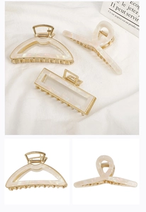 Detailed set of acetate and alloy claw clips on white fabric showing geometric shapes