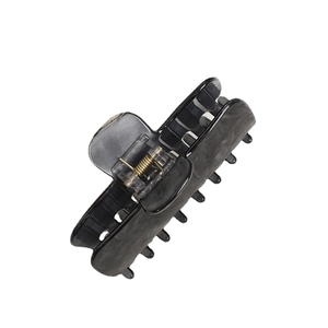 Large dark grey marble acrylic hair claw clip with golden spring on white background