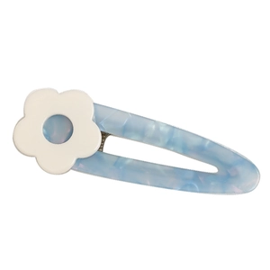 Close-up of a light blue marble-textured acetate hair clip with a small white flower detail