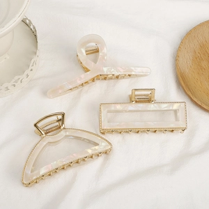 Minimalist gold alloy and cream marble acetate shark hair claws in geometric shapes
