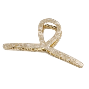Dettaglio macro della molletta per capelli oversize in acetato beige marmorizzato e metallo