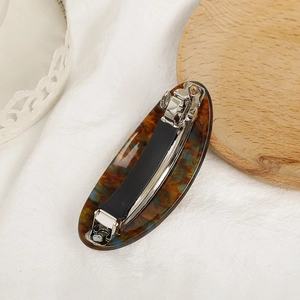 Detail view of acetate hair clip with tortoiseshell texture and anti-slip spring mechanism