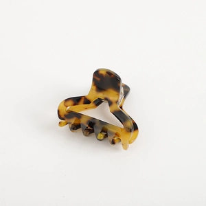 Close-up of tortoise shell pattern acetate hair claw clip with vintage amber texture