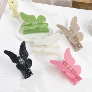 Detailed view of large acrylic butterfly hair clips in five assorted marble colors