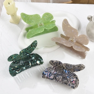 Macro view of four elegant oversized butterfly hair claws in various marble patterns