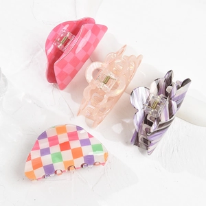 Set of four colorful acrylic hair claw clips with checkered patterns and flower cutouts