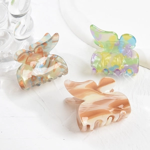 Three acetate butterfly hair claws in marble textures and diverse vibrant colors