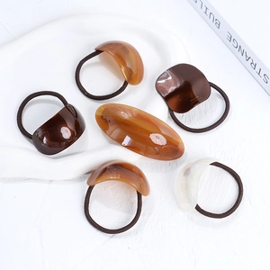 Handmade oval acetate hair ties and clips in amber and cream for elegant ponytails