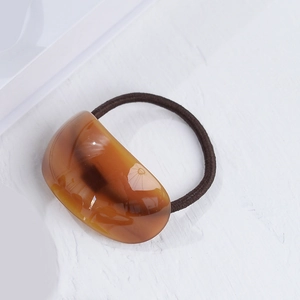 Macro detail of tortoiseshell acetate hair tie showing premium texture and finish