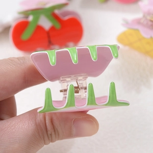 Detail of pink strawberry claw clip showing its spring mechanism and smooth finish