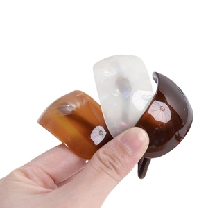 Elegant oval acetate hair ties in pearl white, amber, and brown with smooth glossy finish