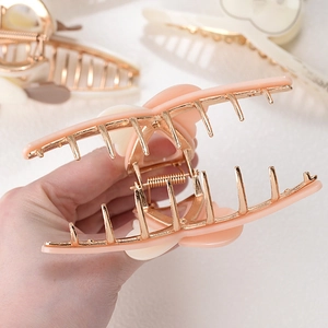 Large pink heart acetate hair claw clip with golden metal frame for elegant hairstyling