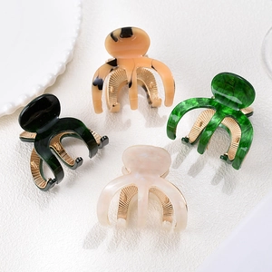 Set di quattro pinze per capelli in acetato marmorizzato con denti in metallo dorato