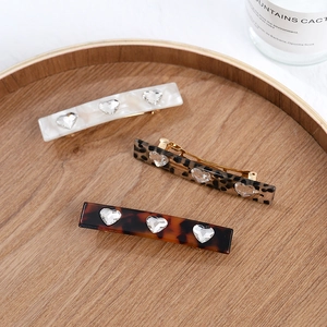 Acetate hair clips with heart crystals in marble, leopard, and tortoiseshell patterns