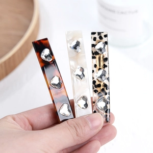 Three acetate hair clips with heart rhinestones in tortoiseshell and marble patterns
