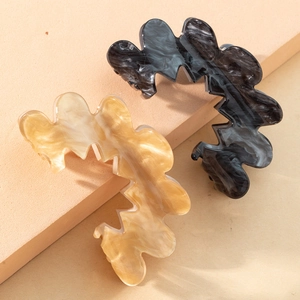 Détail de pinces à cheveux en acrylique ondulé, texture ambre et marbre sur supports