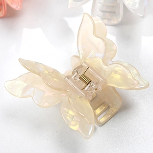 Close-up of iridescent yellow butterfly hair claw clip with a strong gold metal spring